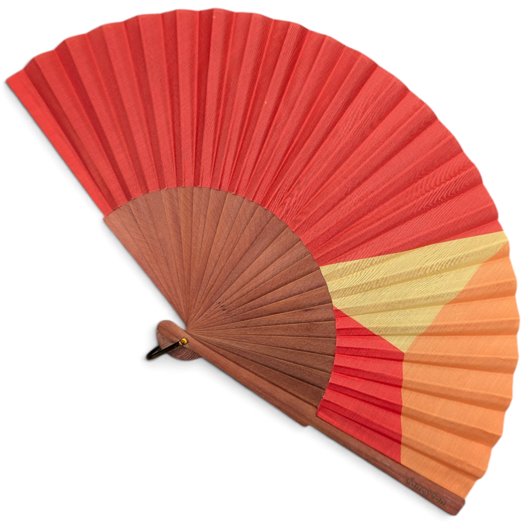 LE BAZAR INOUI SUNSET Handfächer aus Holz und Stoff mit geometrischem Farbverlauf in Rot, Orange und Gelb.
