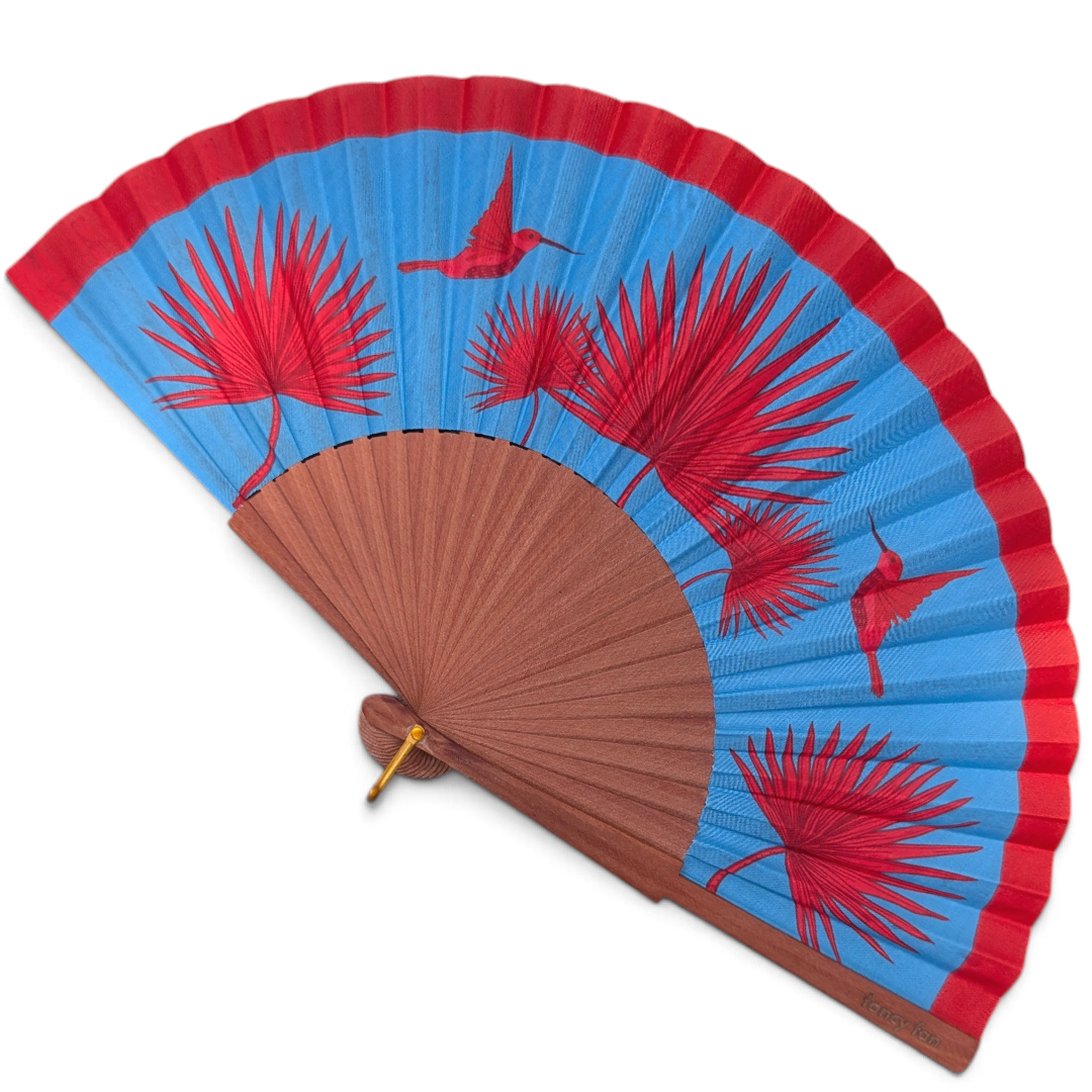 LE BAZAR INOUI Faltfächer mit blauem Stoff, rotem Kolibri- und Palmenprint sowie braunem Holzrahmen.