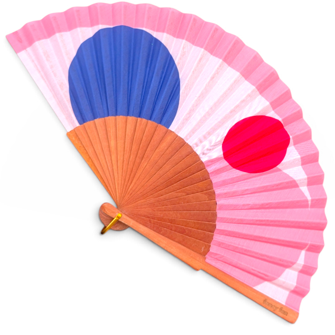 LE BAZAR INOUI PINK BUBBLE Handfächer mit rosa Stoff, blauem und rotem Punktmuster sowie einem Holzrahmen.