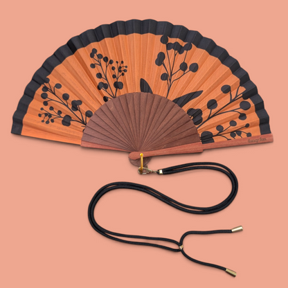 LE BAZAR INOUI RHAPSODY Handfächer aus Holz und Stoff mit orange-schwarzem Blumenmuster und schwarzem Trageband