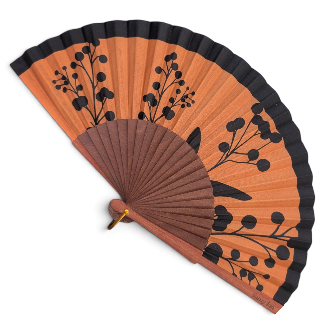 LE BAZAR INOUI Rhapsody Handfächer mit orangefarbenem Stoff, schwarzem Blumenmuster und braunem Holzrahmen.