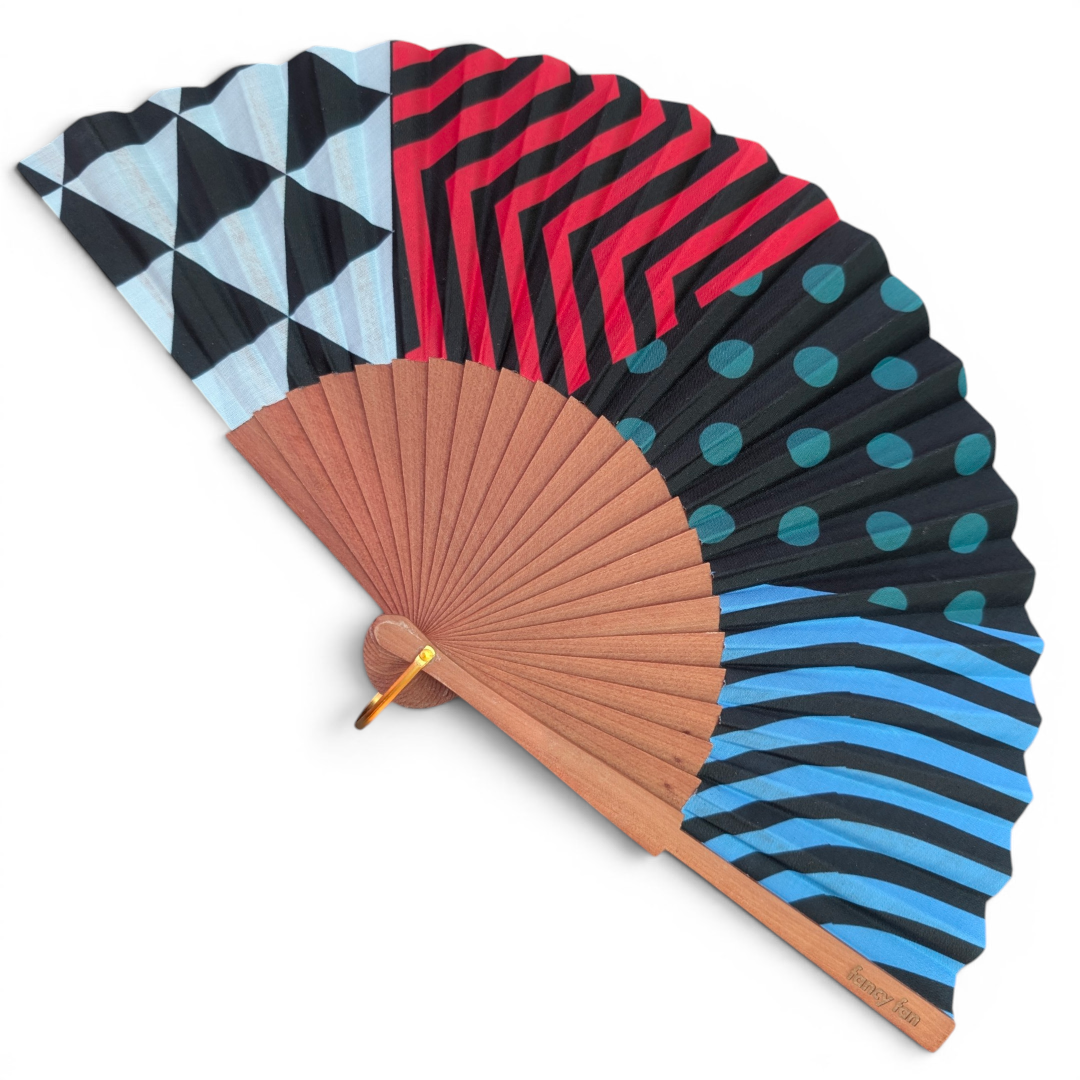 LE BAZAR INOUI RHAPSODY II Fächer mit buntem geometrischem Muster, Holzrahmen und Stoffbespannung.