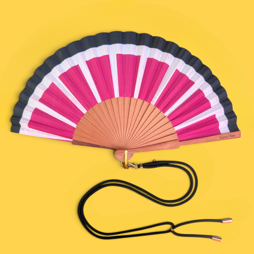 LE BAZAR INOUI SUN RAYS Handfächer aus Holz und Stoff mit pink-weißem Streifenmuster und schwarzem Trageband